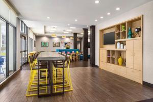 a dining room with a table and yellow stools at Home2 Suites Long Island City/Manhattan View in Queens