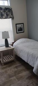 a bedroom with a bed and a table with a lamp at Secluded lodge in the woods. in Iron Mountain