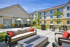 a patio with a couch and tables and chairs at The Homewood Suites by Hilton Ithaca in Ithaca