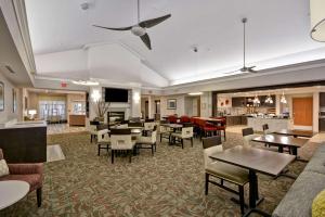 a lobby with tables and chairs and a restaurant at The Homewood Suites by Hilton Ithaca in Ithaca