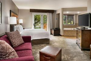 um quarto de hotel com uma cama e uma televisão em Hampton Inn Jackson Hole em Jackson