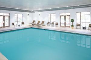 a large swimming pool in a room with windows at Hampton Inn by Hilton Garden City Long Island in Garden City