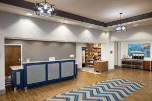 a lobby with a store with a counter and a rug at Hampton Inn by Hilton Garden City Long Island in Garden City