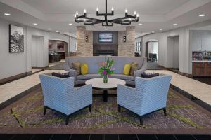 eine Lobby mit einem Sofa, Stühlen und einem Tisch in der Unterkunft Homewood Suites by Hilton Carle Place - Garden City, NY in Carle Place