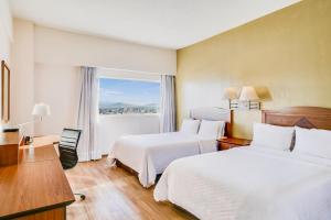 a hotel room with two beds and a window at Fiesta Inn Torreon Galerias in Torreón