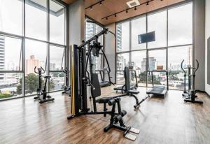 a gym with treadmills and ellipticals in a room with windows at 717 - Rentaqui Studio Elegance Butanta in Sao Paulo