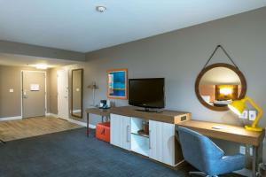 a room with a desk with a tv and a mirror at Hampton Inn and Suites Jamestown in Jamestown