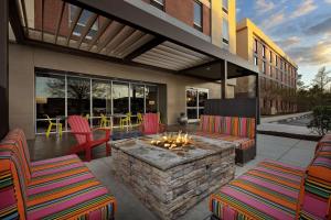 a patio with chairs and a fire pit in a building at Home2 Suites by Hilton Jacksonville, NC in Jacksonville