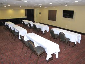 a conference room with white tables and chairs and a screen at Hampton Inn & Suites Jamestown in Jamestown