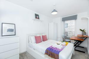 a white bedroom with a bed and a desk at New 2BR wBalcony 1 min Ponders End Train, Enfield in Ponders End
