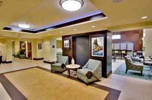 莫雷诺谷Hampton Inn & Suites Moreno Valley的酒店大堂设有椅子和桌子。 更多37张照片