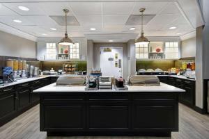 a large kitchen with black cabinets and a large counter at Homewood Suites by Hilton Edgewater-NYC Area in Edgewater