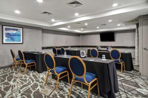 a conference room with tables and chairs and a screen at Homewood Suites by Hilton Edgewater-NYC Area in Edgewater