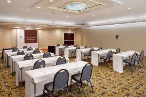 uma sala de conferências com mesas e cadeiras brancas em DoubleTree by Hilton Fayetteville em Fayetteville