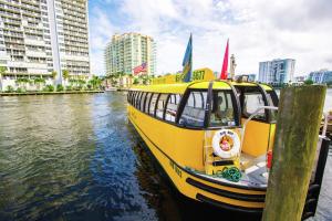 a yellow boat is docked in a river with buildings at GALLERY One - A DoubleTree Suites by Hilton Hotel in Fort Lauderdale