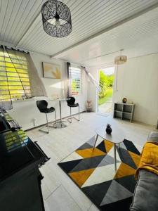 een woonkamer met een bank en een tafel bij Duplex en pleine nature à Vernou by KAZ Départ in Petit-Bourg