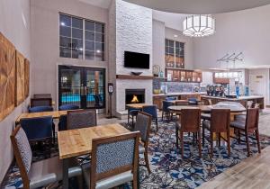 ein Restaurant mit Tischen und Stühlen und einem Kamin in der Unterkunft Homewood Suites by Hilton Greensboro in Greensboro