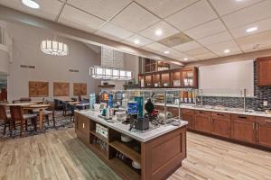 a large kitchen and dining room with tables and chairs at Homewood Suites by Hilton Greensboro in Greensboro