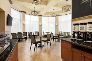 uma sala de jantar com mesas, cadeiras e janelas em Hampton Inn & Suites Greenville-Downtown-Riverplace em Greenville