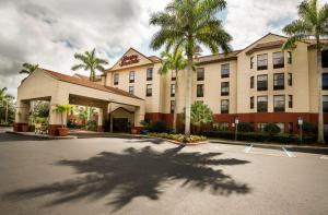 een hotel met palmbomen op een parkeerplaats bij Hampton Inn & Suites Fort Myers Beach/Sanibel Gateway in Fort Myers Beach