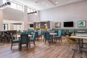 uma sala de jantar com mesas e cadeiras em Hampton Inn & Suites Fort Myers Beach/Sanibel Gateway em Fort Myers Beach