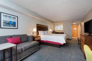 フォートマイヤーズビーチにあるHampton Inn & Suites Fort Myers Beach/Sanibel Gatewayのベッドとソファ付きのホテルルーム