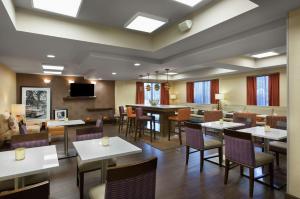 a dining room with tables and chairs and a television at Hampton Inn Greenville/Travelers Rest in Travelers Rest