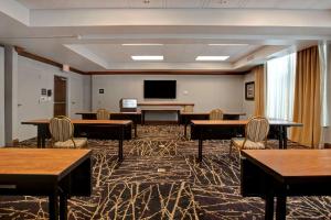 a room with tables and chairs and a flat screen tv at Hampton Inn & Suites Greenville-Downtown-Riverplace in Greenville