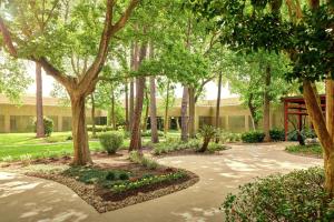 a garden with trees and flowers in front of a building at DoubleTree by Hilton Houston Intercontinental Airport in Houston