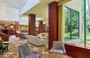 a lobby with chairs and tables and windows at DoubleTree by Hilton Houston Intercontinental Airport in Houston
