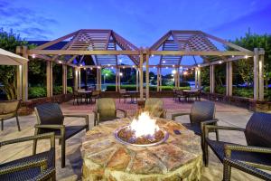 eine Terrasse mit einem Tisch, Stühlen und einer Feuerstelle in der Unterkunft Embassy Suites Greenville Golf Resort & Conference Center in Greenville