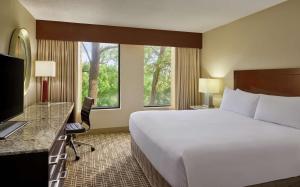 um quarto de hotel com uma cama, uma secretária e uma televisão em DoubleTree by Hilton Houston Intercontinental Airport em Houston