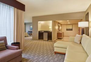 a living room with a white couch and a living room with a kitchen at DoubleTree by Hilton Houston Intercontinental Airport in Houston