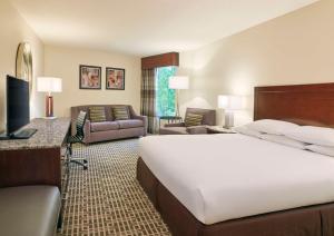a hotel room with a bed and a living room at DoubleTree by Hilton Houston Intercontinental Airport in Houston