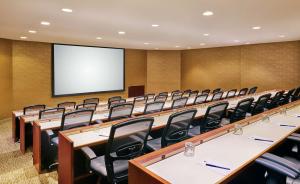a conference room with tables and chairs and a screen at DoubleTree by Hilton Houston Intercontinental Airport in Houston