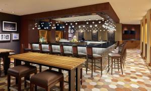 a bar in a restaurant with chairs and tables at DoubleTree by Hilton Houston Intercontinental Airport in Houston