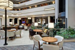 a lobby of a hotel with tables and chairs at Embassy Suites Greenville Golf Resort & Conference Center in Greenville
