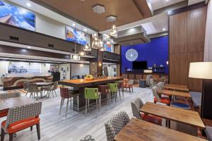 a restaurant with tables and chairs and a bar at Hampton Inn & Suites Houston-Bush Intercontinental Airport in Houston