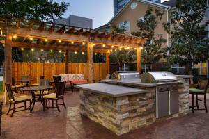 an outdoor kitchen and dining area with a pergola at Homewood Suites by Hilton Houston-Westchase in Houston