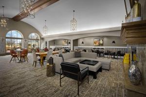 - un salon avec un canapé, des tables et des chaises dans l'établissement Homewood Suites by Hilton at The Waterfront, à Wichita