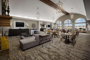 sala de estar con sofá, sillas y TV en Homewood Suites by Hilton at The Waterfront en Wichita