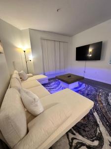 a living room with a white couch and a flat screen tv at The Avalon in Clearwater