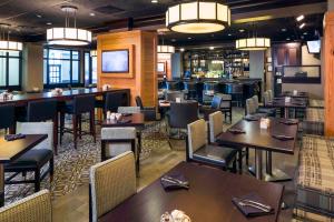 um restaurante com mesas e cadeiras e um bar em DoubleTree by Hilton Hotel Wilmington em Wilmington