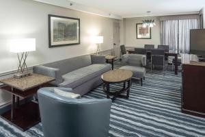 a hotel room with a couch and chairs and a living room at DoubleTree by Hilton Hotel Wilmington in Wilmington