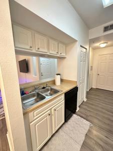 a kitchen with white cabinets and a sink at The Avalon in Clearwater