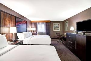 a hotel room with two beds and a desk at DoubleTree by Hilton Downtown Wilmington - Legal District in Wilmington