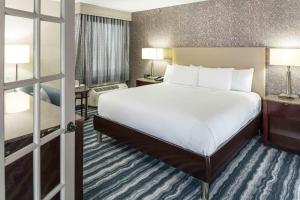 DoubleTree by Hilton Hotel Wilmington في ويلمنغتون: غرفة فندقية بسرير كبير ونافذة