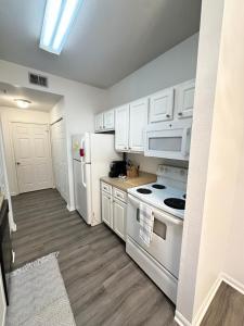 a kitchen with white appliances and white cabinets at The Avalon in Clearwater