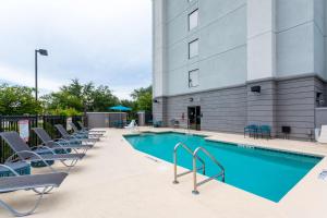 uma piscina com cadeiras e um edifício em Hampton Inn Jacksonville-I-295 East/Baymeadows em Jacksonville