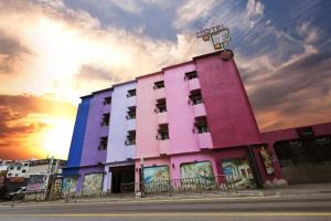 a pink building with a sunset in the background at Amant Hotel in Goyang